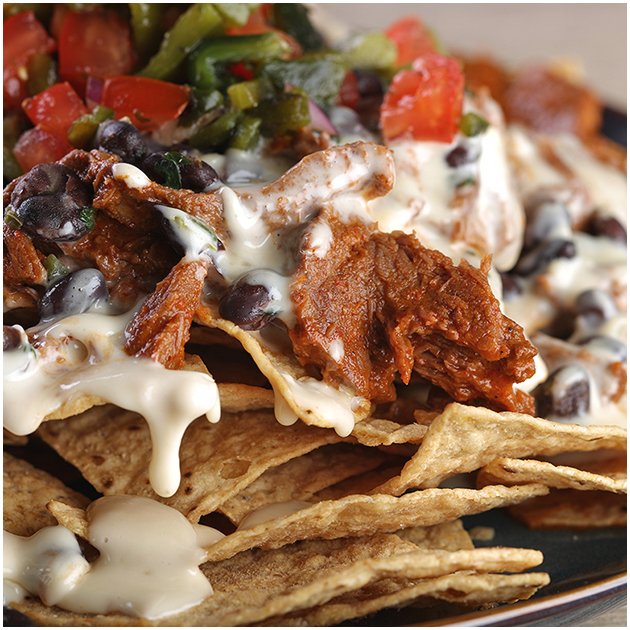 Nachos topped with beef, cheese, and vegetables