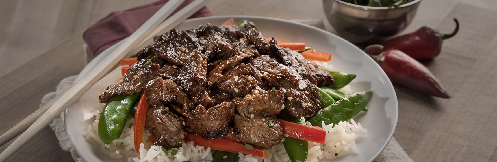 Beef stir fry on plate with chop sticks