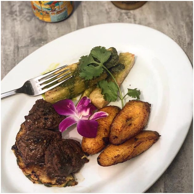 Meat on a plate with veggies and garnish