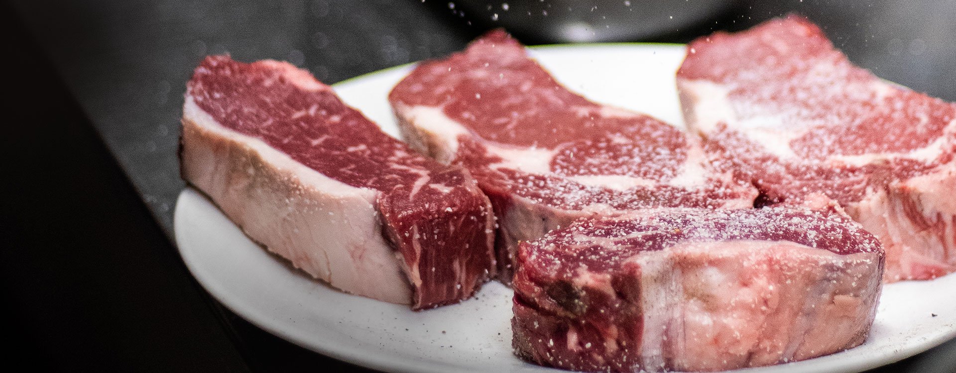 Sprinkling salt on raw steak