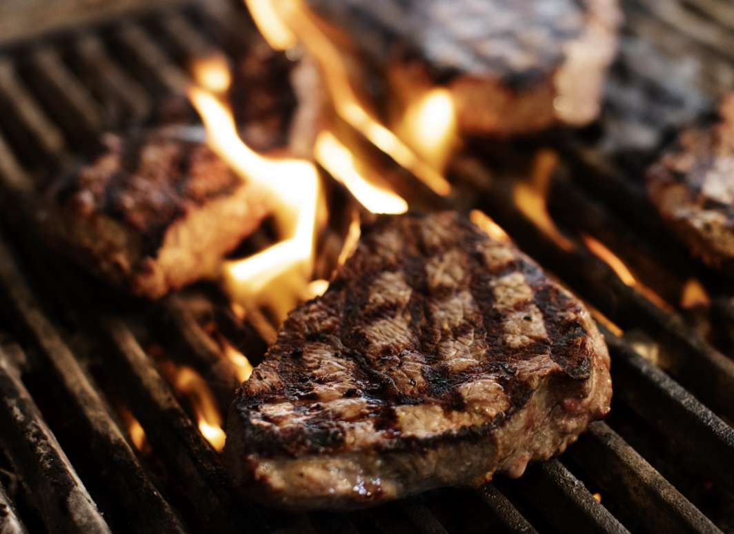 Steaks searing on a grill