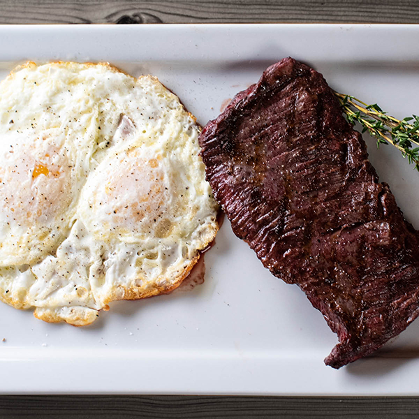 Steak and eggs on a white plate